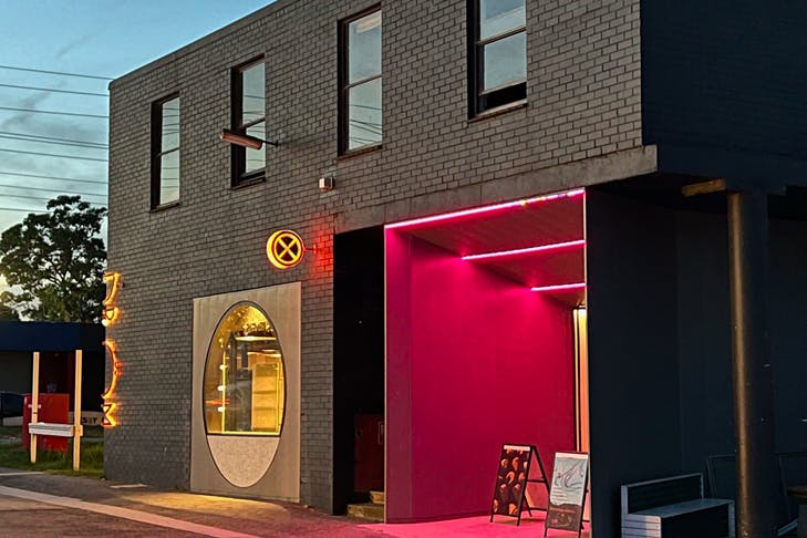 The outside of a bakery lit up at night.